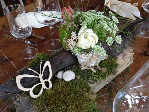 einem Tisch mit einem Kernstück aus Blumen und Pflanzen in der Unterkunft Seyberth´s Chalet in Siefersheim