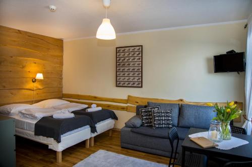 a bedroom with a bed and a couch at Pensjonat Iskra in Sztum