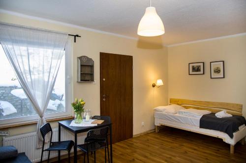 a bedroom with a bed and a table and a window at Pensjonat Iskra in Sztum