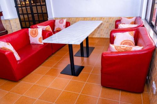 two red couches and a table and two chairs at Easy Hotel Kenya in Nairobi