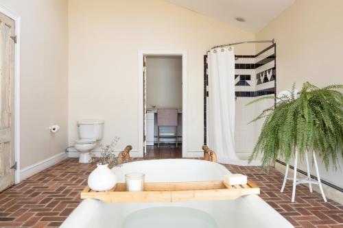 y baño con bañera y aseo. en River House by AvantStay Historic Secluded Estate on the Hudson River w Pool Sleeps 24, en Hudson