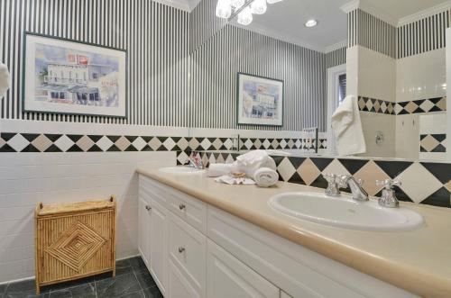 a bathroom with a sink and a mirror at Amelia Home by AvantStay In Historic Old Town w Pool in Key West