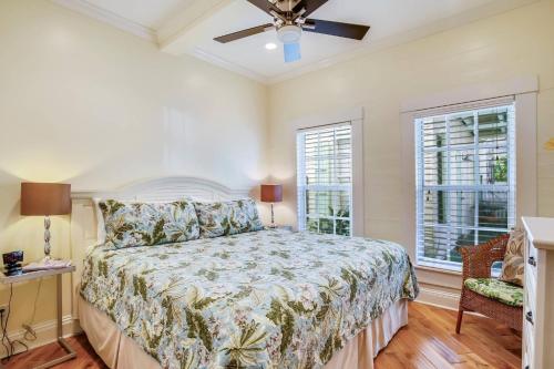 a bedroom with a bed and two windows at Paradise Place by AvantStay Key West Old Town Condo w Shared Pool in Key West