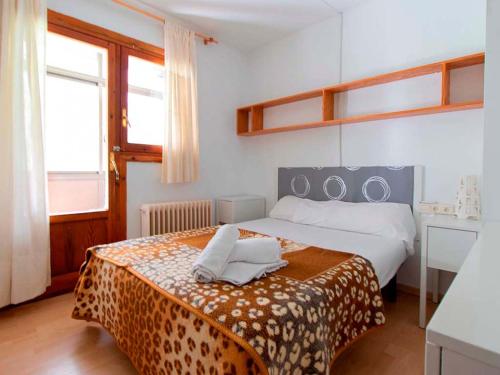 1 dormitorio con 1 cama con manta de guepardo en Apartamentos 3000 Formigal en Formigal