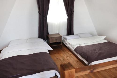 two beds in a room with a window at Lara Bungalow Suit in Perşembe