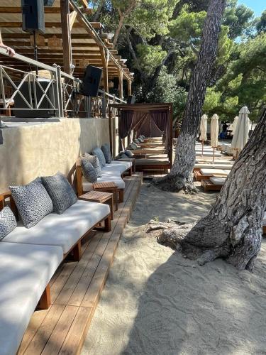 a row of chaise lounges on a deck with a tree at Xenia Poros Image Hotel in Poros