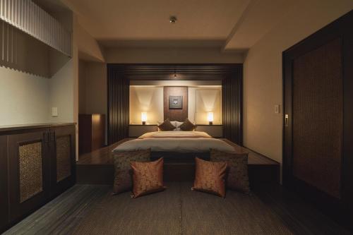 a bedroom with a large bed with two pillows at SAKE Kura Hotel 川崎宿 in Kawasaki