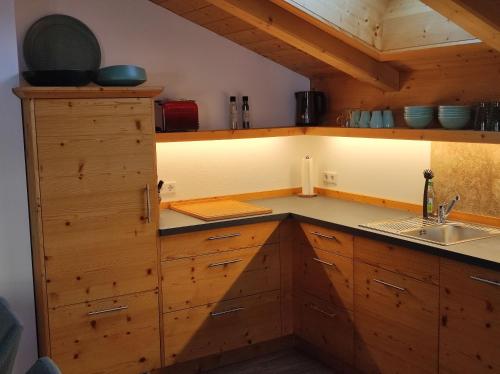 a kitchen with wooden cabinets and a sink at Ferienwohnungen Rohnbogner in Point