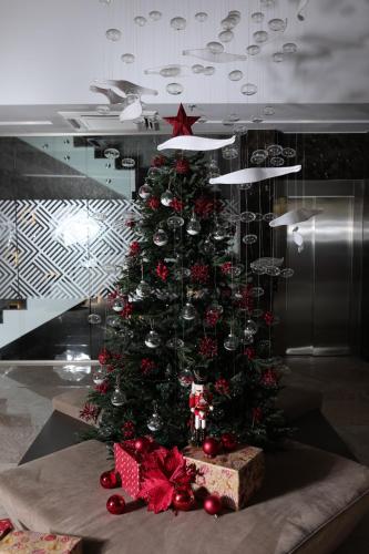 a christmas tree with red bows and a box at Venus Hotel in Pristina
