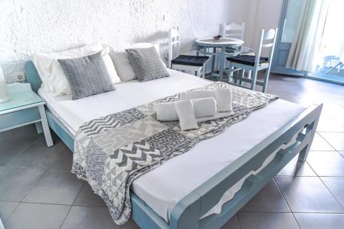 a bedroom with a bed and a table with chairs at Smarula Villa in Firostefani