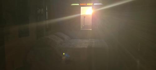 a room with a bed and a window with a light at Red Rose in Cabo Frio