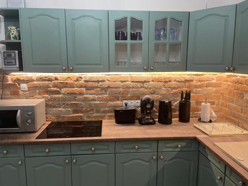 a kitchen with green cabinets and a counter top at Egri Leányka Vendégház in Eger