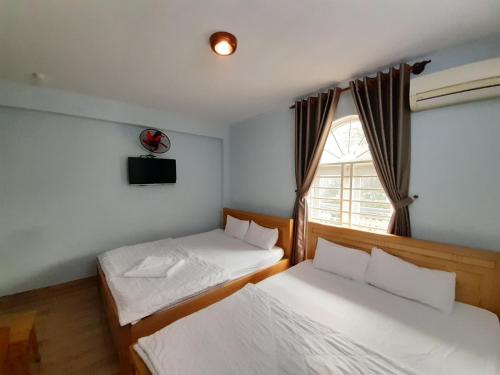 Duas camas num quarto com uma janela em Capital O 1221 Thien An Hotel em Ho Chi Minh