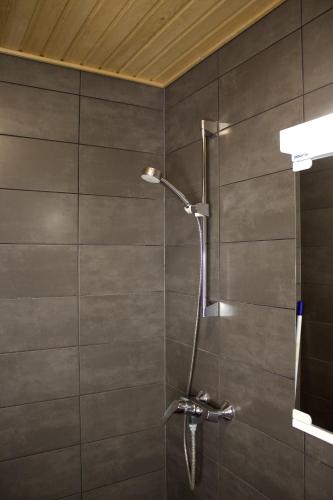 a shower with a shower head in a bathroom at Vuokatti Slope Studio in Vuokatti