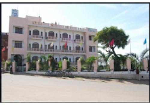 ein großes rosafarbenes Gebäude mit Fahrrädern davor in der Unterkunft Hotel Fort View Madhya Pradesh in Tīkamgarh
