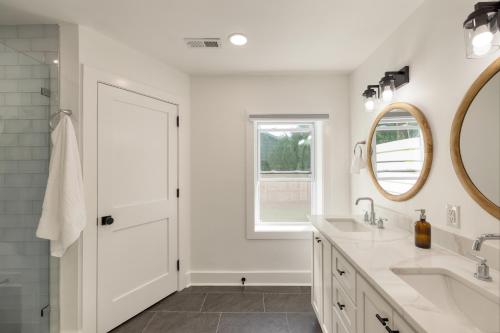 uma casa de banho branca com um lavatório e um espelho em Lumie by AvantStay 5BR Ranch w Firepit Patio em Isle of Palms