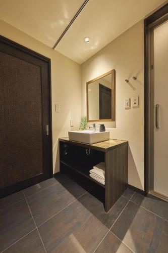 a bathroom with a sink and a mirror at SAKE Kura Hotel 川崎宿 in Kawasaki