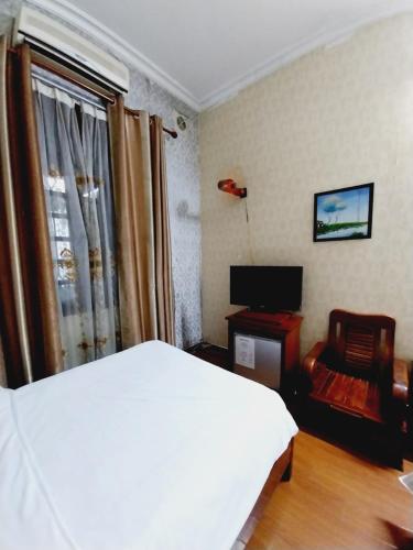 a bedroom with a bed and a chair and a television at Holiday Home in Hanoi