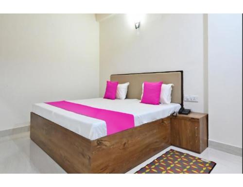 1 dormitorio con 1 cama grande con almohadas rosas en Hotel Raj Inn, Agra en Agra