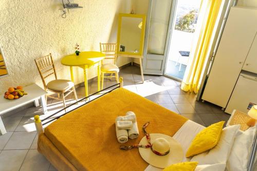 フィロステファニにあるスマルラ ヴィラのベッド、テーブル、椅子が備わる客室です。