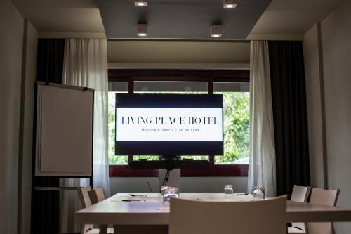 a television in a room with a table and chairs at Living Place Hotel in Villanova