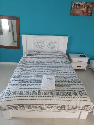 a white bed in a blue room with a mirror at הירקון 10 in Tel Aviv