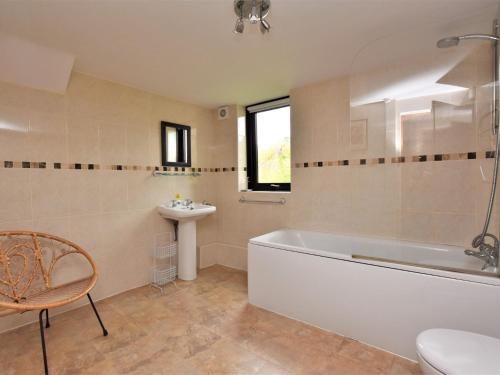 a bathroom with a tub and a sink and a toilet at 2 Bed in Holmesfield PK783 in Dronfield