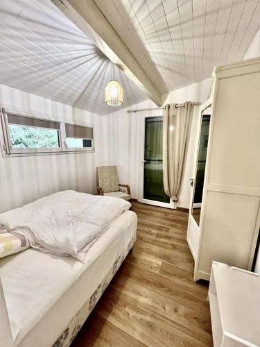 une chambre avec un lit et une chaise dedans dans l'établissement Maison rénovée avec vue exceptionnelle sur le lac, à Lacanau