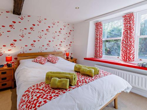 バスロウにある3 Bed in Baslow PK917のベッドルーム1室(赤と白の枕が備わるベッド1台付)
