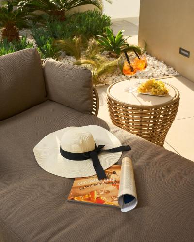 a hat and a plate of food on a couch at Mirari Boutique Hotel in Split