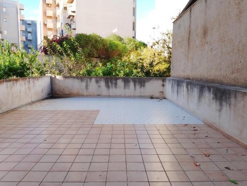 an empty patio with a tile floor and buildings at Calliope in Marsala