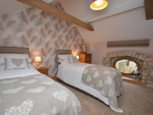 1 dormitorio con 2 camas y pared de piedra en 2 Bed in Bath 47045 en Farmborough