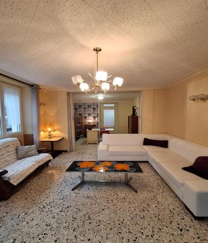 a living room with a white couch and a table at Le Cep de Bouzy gite 6 personnes au cœur du vignoble champenois in Bouzy