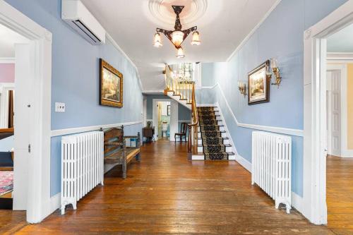 un couloir d'une maison avec des murs bleus et un escalier dans l'établissement Stay in Historic Manor House, à Bensalem