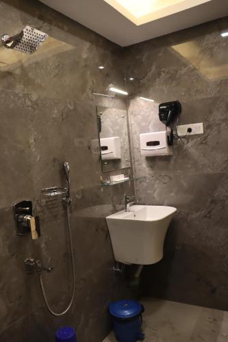 un baño con lavabo y ducha en Hotel Sweet Villa Puri, en Puri