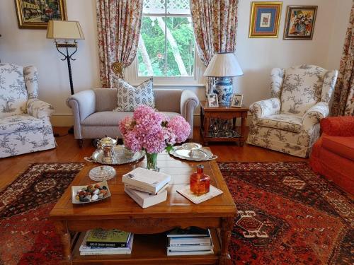 a living room with a coffee table with flowers on it at Yellowwood Lodge in Knysna