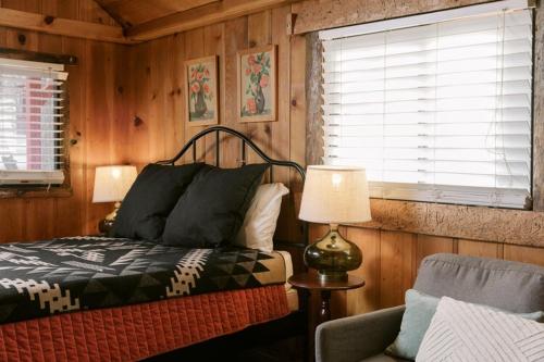 een slaapkamer met een bed, een lamp en een stoel bij 2405 - Oak Knoll Studio #6 cabin in Big Bear Lake