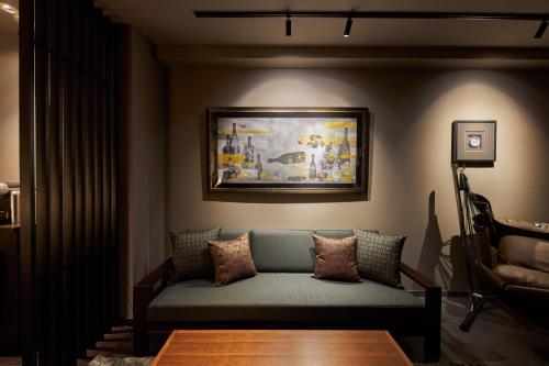 a living room with a couch and a painting on the wall at SAKE Kura Hotel 川崎宿 in Kawasaki