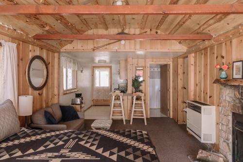 een woonkamer met houten wanden en een open haard bij 2404 - Oak Knoll Studio #5 cabin in Big Bear Lake