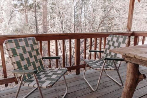 twee stoelen en een houten tafel op een veranda bij 2404 - Oak Knoll Studio #5 cabin in Big Bear Lake