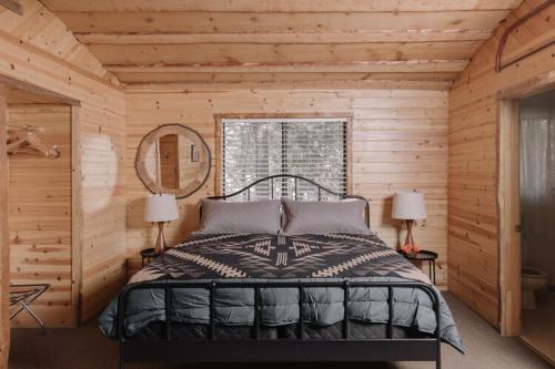 1 dormitorio con 1 cama en una cabaña de madera en 2408 - Oak Knoll ADA Studio #10 cabin en Big Bear Lake