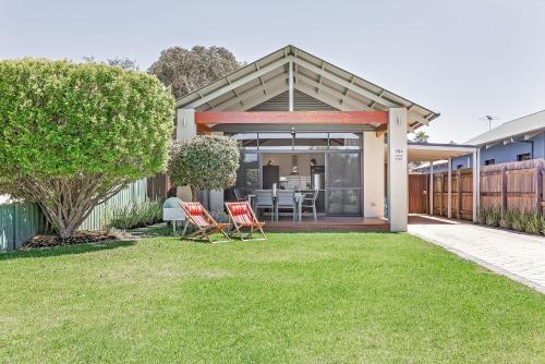 a home with a patio with chairs on the grass at Footsteps By The Bay in Dunsborough