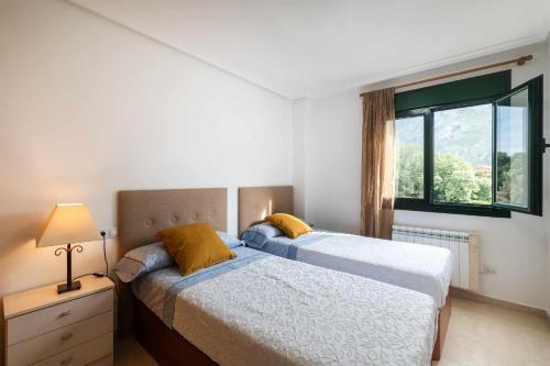 1 dormitorio con 2 camas y ventana en Apartamento Llanes Paraiso 206, en Posada de Llanes