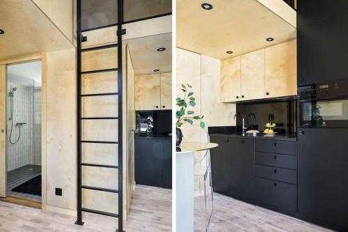 a kitchen with black cabinets and a ladder in it at Peaceful studio loft, Stockholm in Stockholm