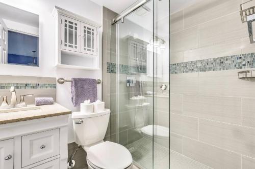 a bathroom with a toilet and a glass shower at Lavender Jungle by AvantStay Great Location w Patio Shared Pool Week Long Stays Only in Key West