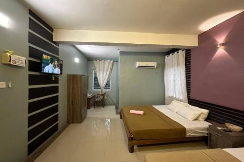 a bedroom with a bed and a flat screen tv at Bull & Bear Airport Hotel Langkawi in Kuah