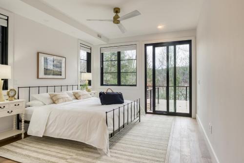 een witte slaapkamer met een groot bed en ramen bij Forget-Me-Not by AvantStay Bold Lakefront Escape in Monterey
