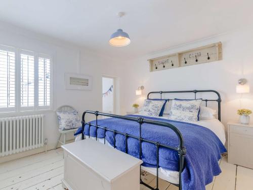 a bedroom with a bed with a blue comforter at 3 Bed in Whitstable WCC20 in Whitstable