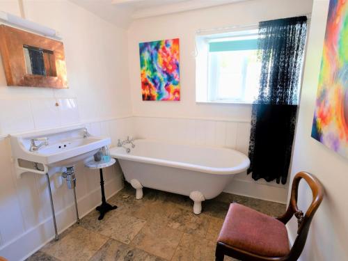 y baño con bañera blanca y lavamanos. en 4 Bed in Godshill IC034, en Godshill