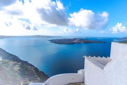 a view of the ocean from a white building at Smarula Villa in Firostefani